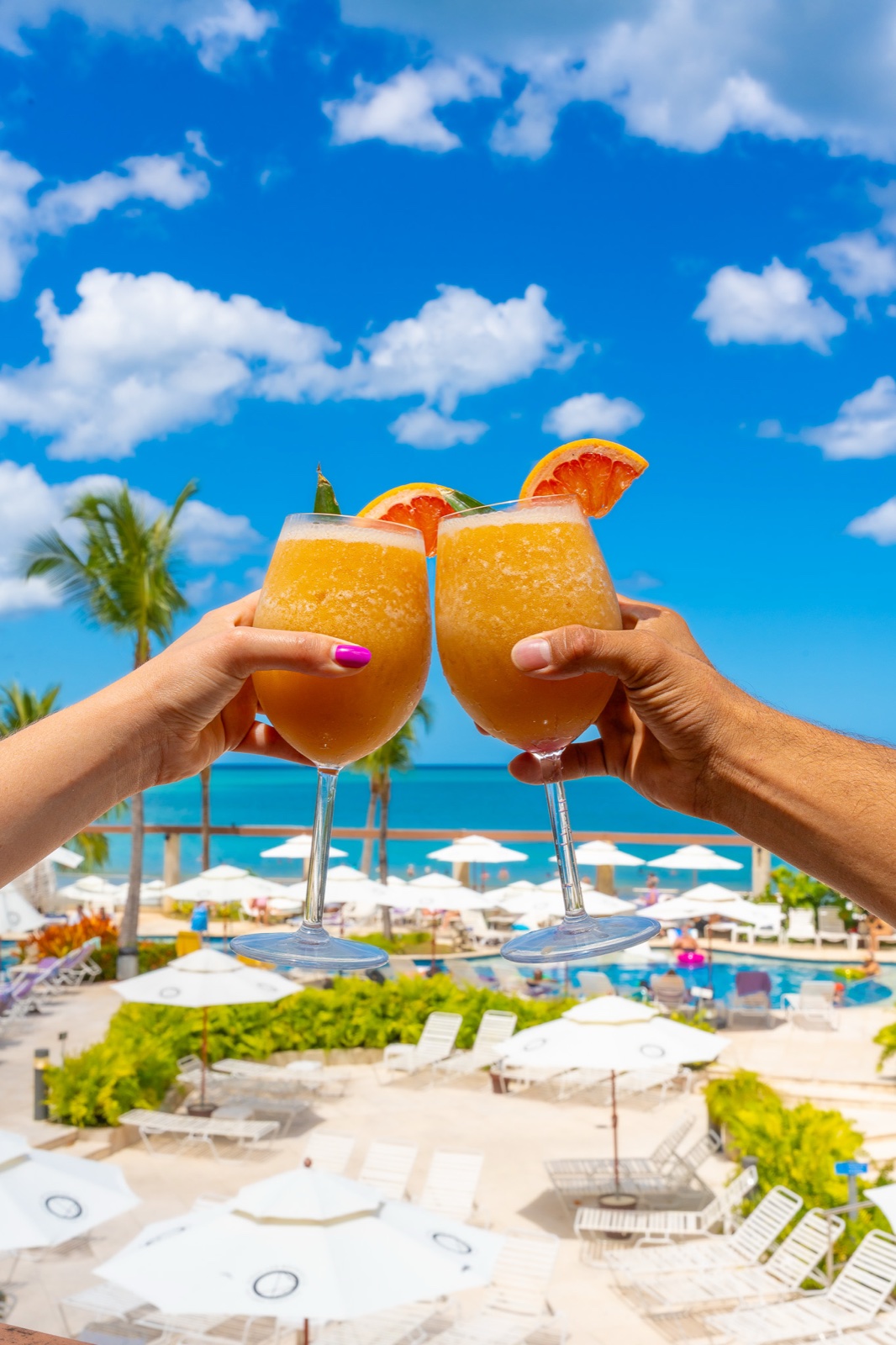 Tropical drinks raised over the Vivo Beach Club pool and beach